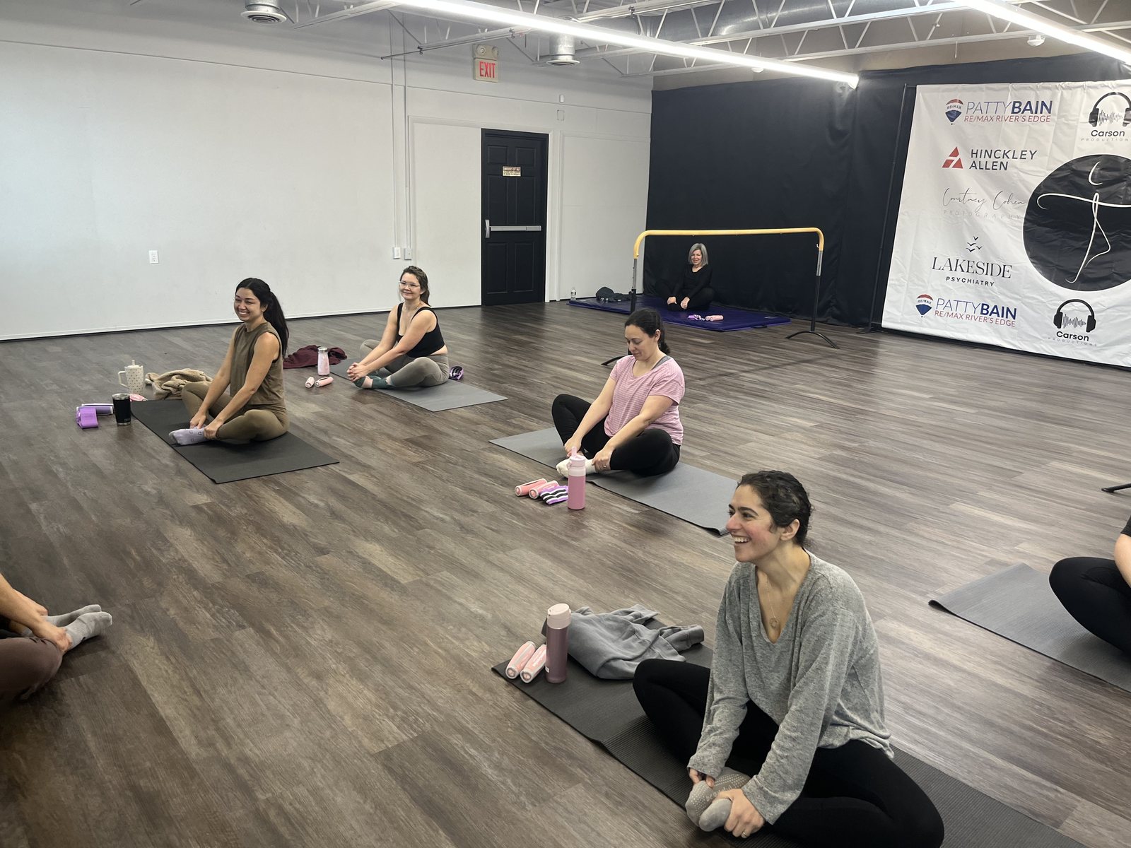 Adults sharing a movement class on exercise mats inside the Barrington studio